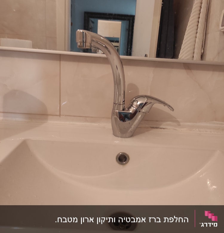 ברז כרום מותקן על כיור לבן בחדר אמבטיה